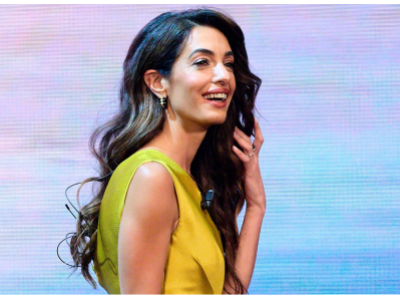 Amal Clooney jest mistrzynią mieszania faktur w białym pluszowym płaszczu i butach do ud z krokodyla.